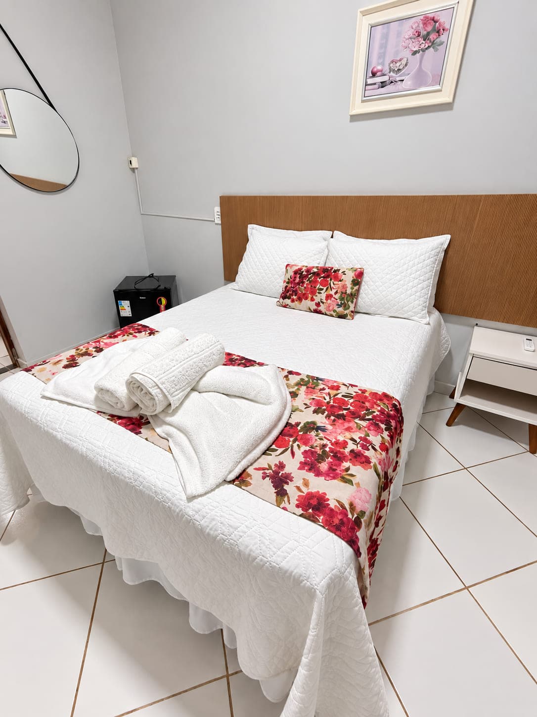 Quarto de casal do Garden Hotel com cama de casal, frigobar e criado-mudo
